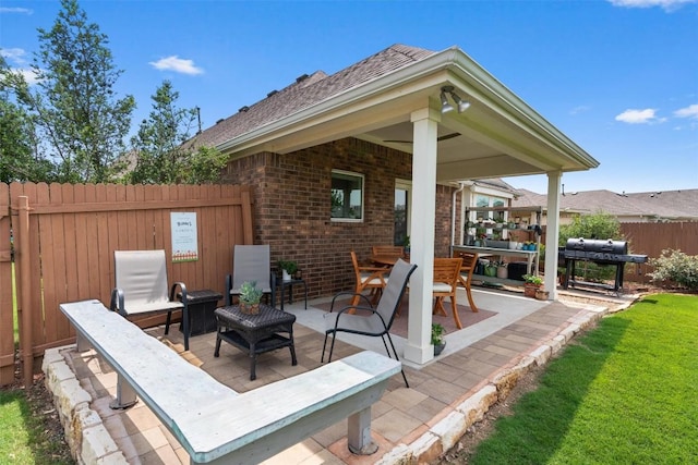 view of patio / terrace with a grill and fence