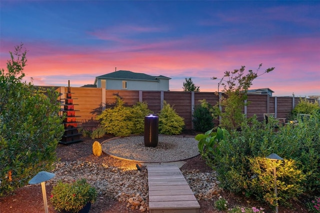 yard at dusk featuring fence