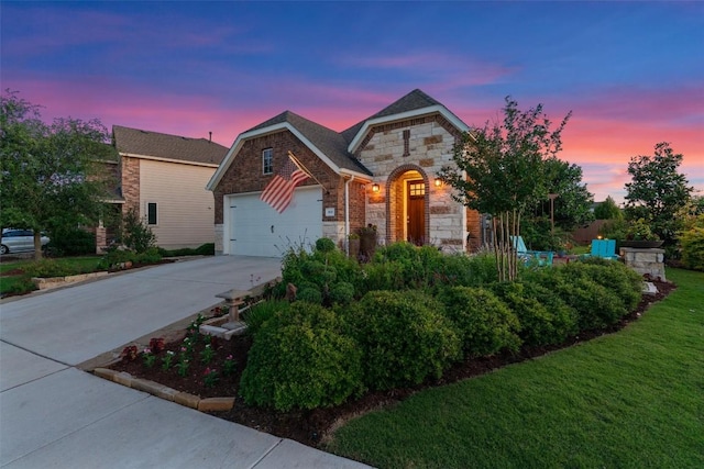 view of front of house featuring stone siding, an attached garage, and driveway