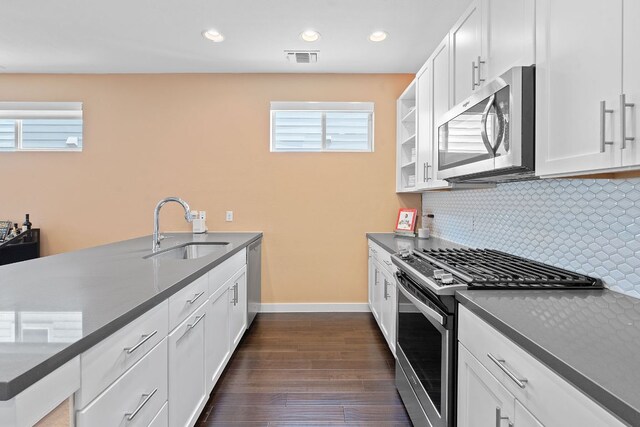 3105 Aldwyche Dr, Austin, TX 78704 - kitchen featuring stainless steel appliances, a sink, dark wood finished floors, backsplash, and white cabinets
