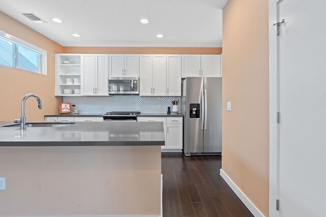 3105 Aldwyche Dr, Austin, TX 78704 - kitchen featuring stainless steel appliances, a sink, white cabinetry, tasteful backsplash, and recessed lighting
