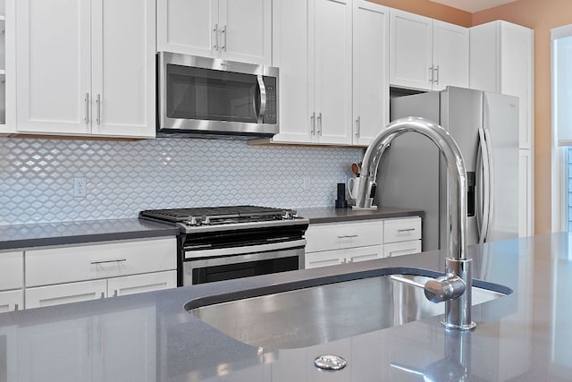 3105 Aldwyche Dr, Austin, TX 78704 - kitchen featuring appliances with stainless steel finishes, dark countertops, and white cabinetry