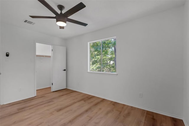 unfurnished bedroom featuring light wood-style floors, baseboards, a closet, and ceiling fan