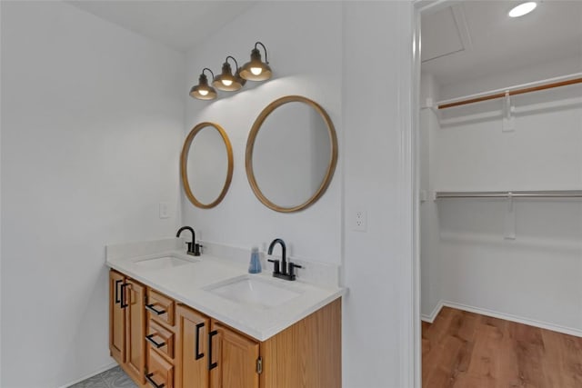 full bath featuring wood finished floors, double vanity, and a spacious closet