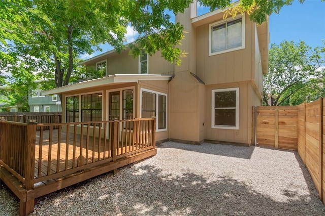 rear view of property featuring a wooden deck and a fenced backyard