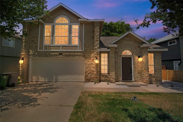 view of front of home featuring stone siding, a garage, and driveway
