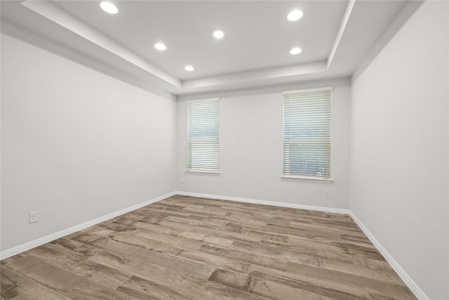 5213 Fresno Ave, Pflugerville, TX 78660 - spare room featuring a tray ceiling, recessed lighting, plenty of natural light, and wood finished floors