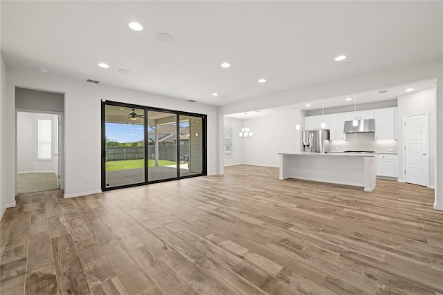 5213 Fresno Ave, Pflugerville, TX 78660 - unfurnished living room featuring light wood-style floors and recessed lighting