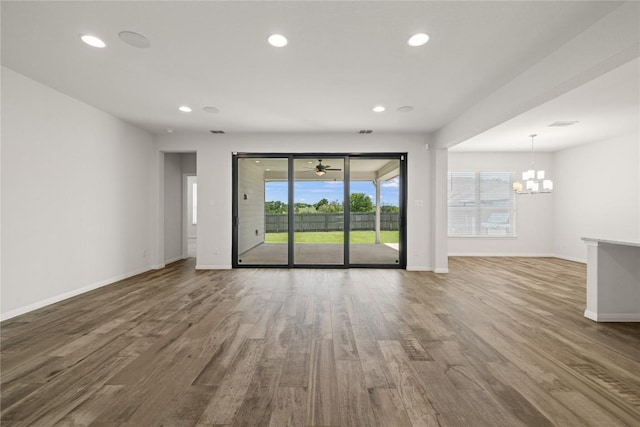 5213 Fresno Ave, Pflugerville, TX 78660 - unfurnished living room featuring wood finished floors, a chandelier, recessed lighting, and ceiling fan
