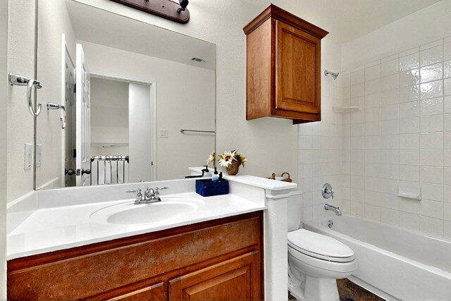 full bath featuring toilet, vanity, and tub / shower combination
