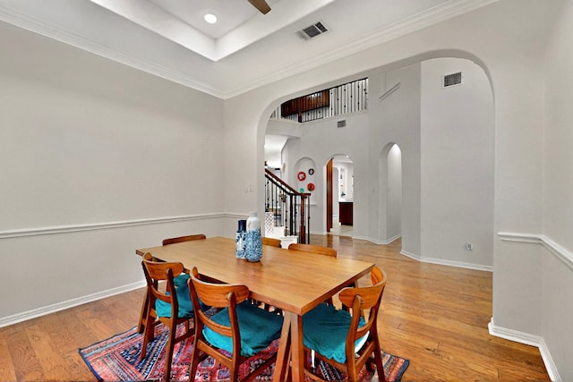 16525 Broadbay Dr, Austin, TX 78717 - dining space with arched walkways, stairway, light wood-style floors, ceiling fan, and baseboards
