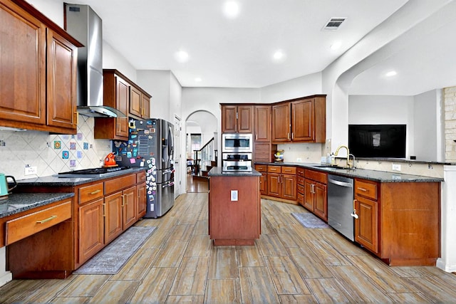 16525 Broadbay Dr, Austin, TX 78717 - kitchen with stainless steel appliances, wall chimney range hood, a center island, a sink, and a peninsula