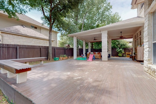 wooden terrace with a ceiling fan and a fenced backyard
