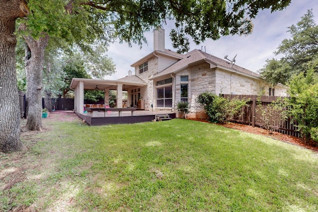 back of property featuring stone siding, a chimney, and a patio