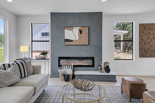214 Ulupau Cir, Bastrop, TX 78602 - living room with wood finished floors, a glass covered fireplace, plenty of natural light, recessed lighting, and baseboards