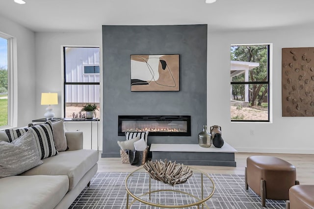 214 Ulupau Cir, Bastrop, TX 78602 - living room with wood finished floors, a glass covered fireplace, plenty of natural light, and recessed lighting