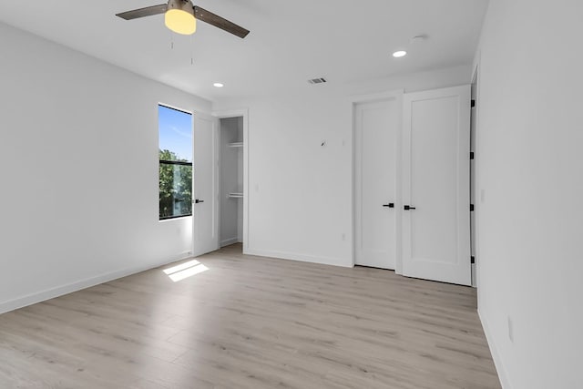 214 Ulupau Cir, Bastrop, TX 78602 - unfurnished bedroom featuring light wood finished floors, recessed lighting, two closets, and ceiling fan