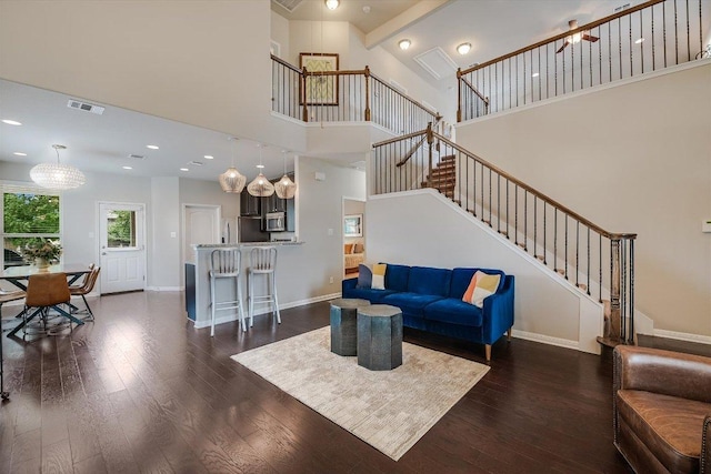 1812 Morts Pl, Manchaca, TX 78652 - living room with stairs, dark wood-style floors, a high ceiling, and baseboards