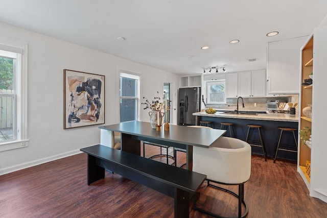 dining room featuring dark wood-type flooring, baseboards, and recessed lighting