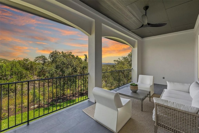 balcony at dusk featuring a ceiling fan and an outdoor living space