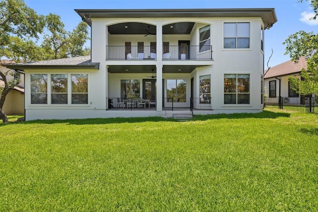 back of house with a balcony, a ceiling fan, and stucco siding