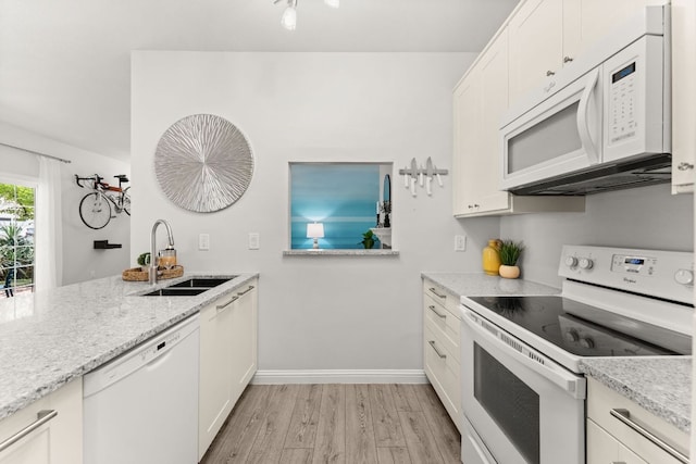 4015 Speedway Unit 1, Austin, TX 78751 - kitchen featuring white appliances, light wood-style floors, light stone countertops, and white cabinetry