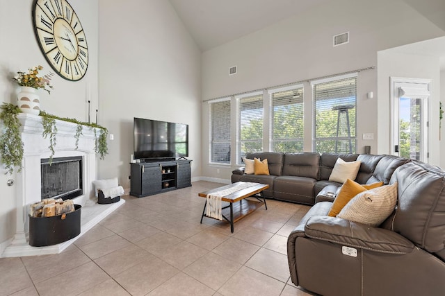 living area featuring high vaulted ceiling, light tile patterned flooring, a premium fireplace, and baseboards