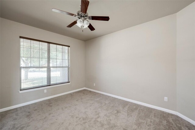 spare room with carpet flooring, baseboards, and a ceiling fan