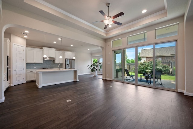 19817 Chayton Cir, Pflugerville, TX 78660 - unfurnished living room with arched walkways, ornamental molding, ceiling fan, dark wood-style floors, and recessed lighting