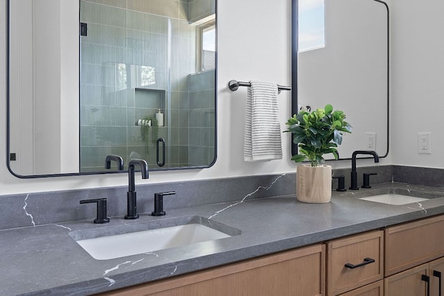 bathroom featuring a shower stall and double vanity