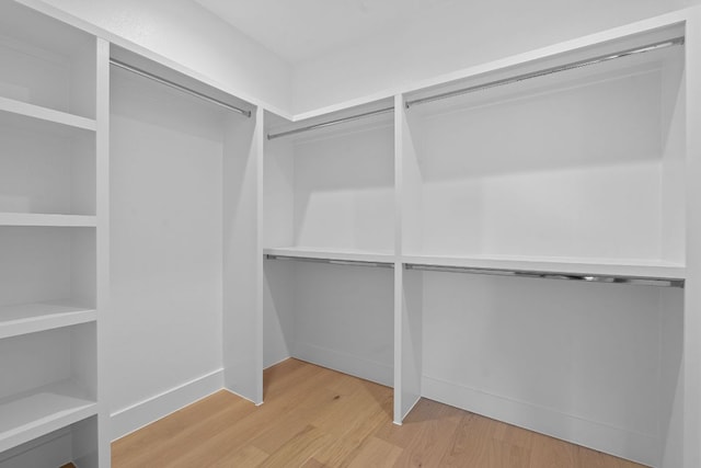 walk in closet with wood finished floors