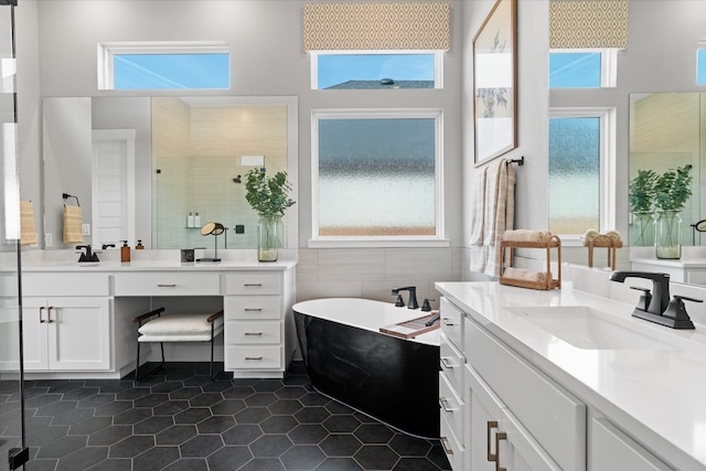 1026 Painted Horse Dr, Georgetown, TX 78633 - full bathroom featuring tile walls, a freestanding bath, tile patterned floors, healthy amount of natural light, and a towering ceiling