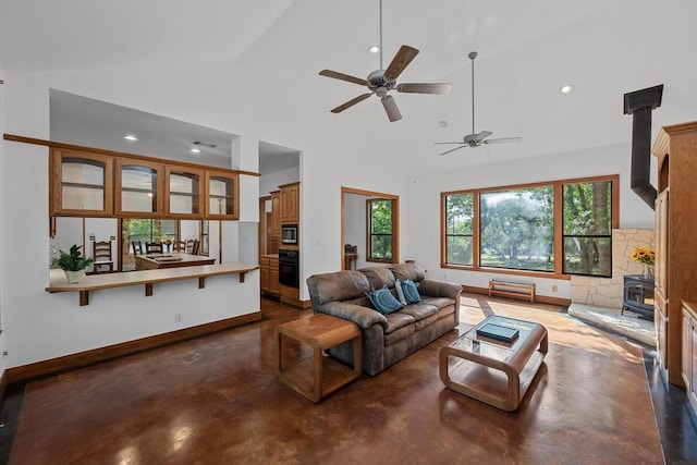 16704 Post Oak Gln, Austin, TX 78737 - living room featuring a wood stove, concrete flooring, a ceiling fan, lofted ceiling, and recessed lighting