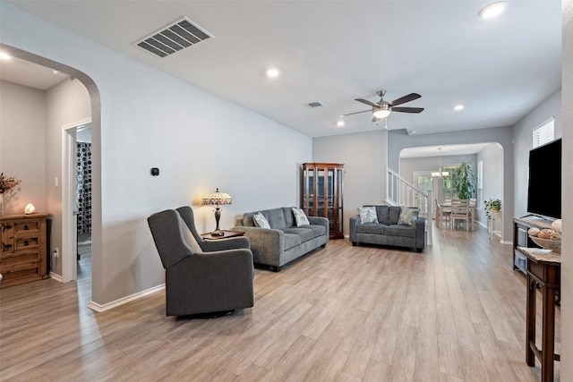 446 Thunder Valley Trl, Georgetown, TX 78626 - living room with arched walkways, light wood-style floors, ceiling fan, recessed lighting, and a chandelier