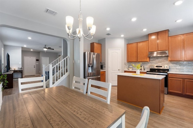 446 Thunder Valley Trl, Georgetown, TX 78626 - kitchen with stainless steel appliances, under cabinet range hood, a kitchen island, backsplash, and light countertops