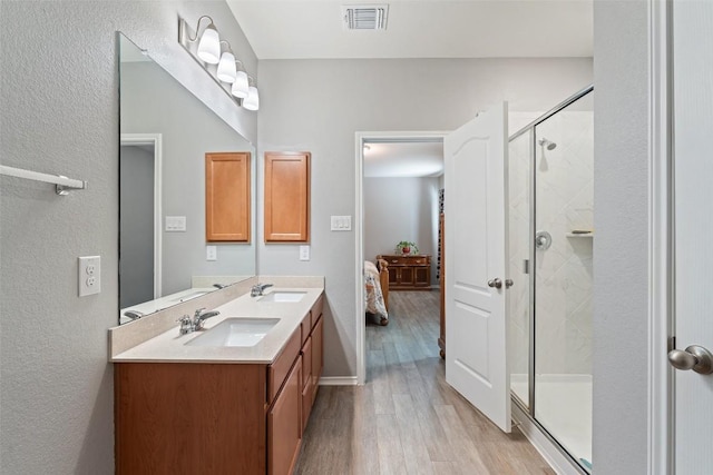 446 Thunder Valley Trl, Georgetown, TX 78626 - bathroom featuring double vanity, wood finished floors, a stall shower, and connected bathroom