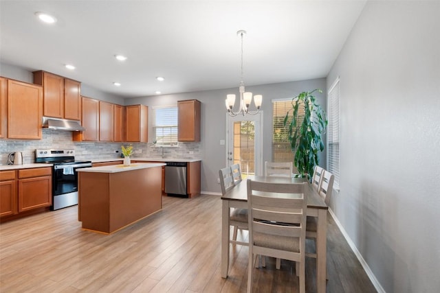 446 Thunder Valley Trl, Georgetown, TX 78626 - kitchen featuring stainless steel appliances, under cabinet range hood, a chandelier, decorative backsplash, and light countertops