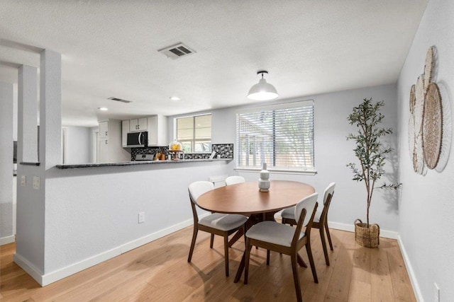 dining room with light wood-style flooring, baseboards, and recessed lighting