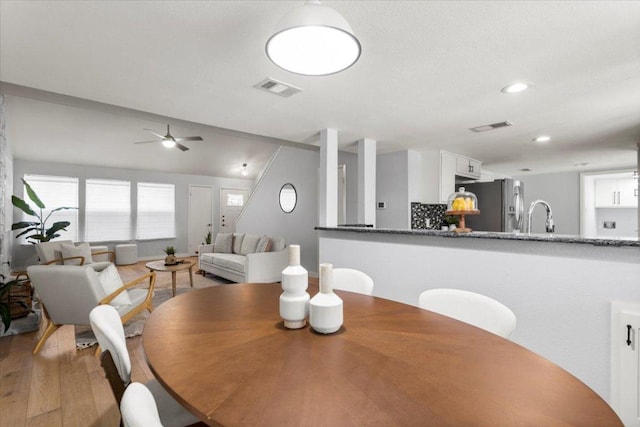dining space with wood finished floors, ceiling fan, and recessed lighting