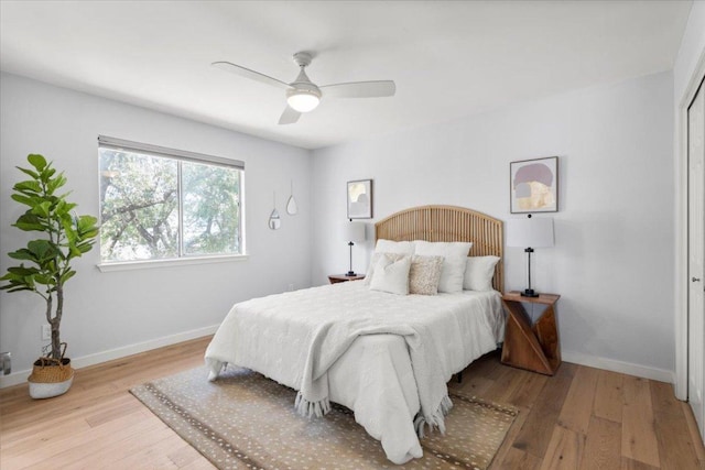 bedroom featuring wood finished floors, baseboards, and a ceiling fan