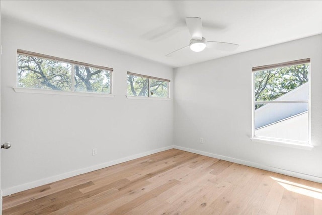 empty room featuring light wood-style floors, baseboards, and a ceiling fan
