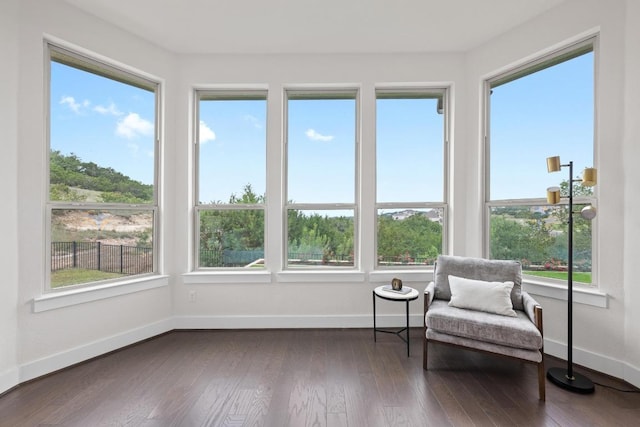 sunroom / solarium featuring baseboards, wood finished floors, and healthy amount of natural light