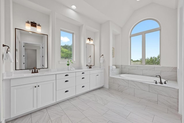 bathroom with plenty of natural light, double vanity, a bath, lofted ceiling, and recessed lighting