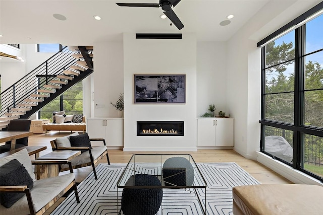 903 Alexia Ln, Austin, TX 78746 - living room with stairs, a glass covered fireplace, healthy amount of natural light, light wood-style flooring, and recessed lighting