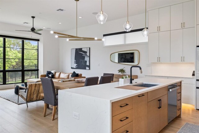 903 Alexia Ln, Austin, TX 78746 - kitchen with a sink, open floor plan, light wood-style floors, light countertops, and recessed lighting