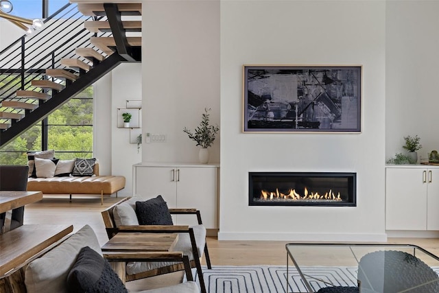 903 Alexia Ln, Austin, TX 78746 - living room featuring light wood-type flooring, stairs, a glass covered fireplace, and healthy amount of natural light