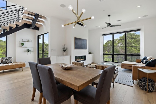 903 Alexia Ln, Austin, TX 78746 - dining room with light wood-type flooring, a glass covered fireplace, healthy amount of natural light, and recessed lighting