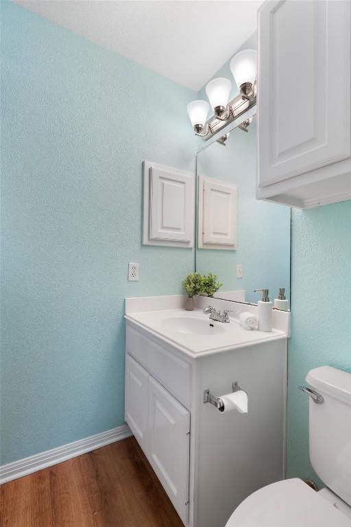 17112 Crescent Heights Trl, Austin, TX 78717 - bathroom featuring vanity, wood finished floors, toilet, baseboards, and a textured wall