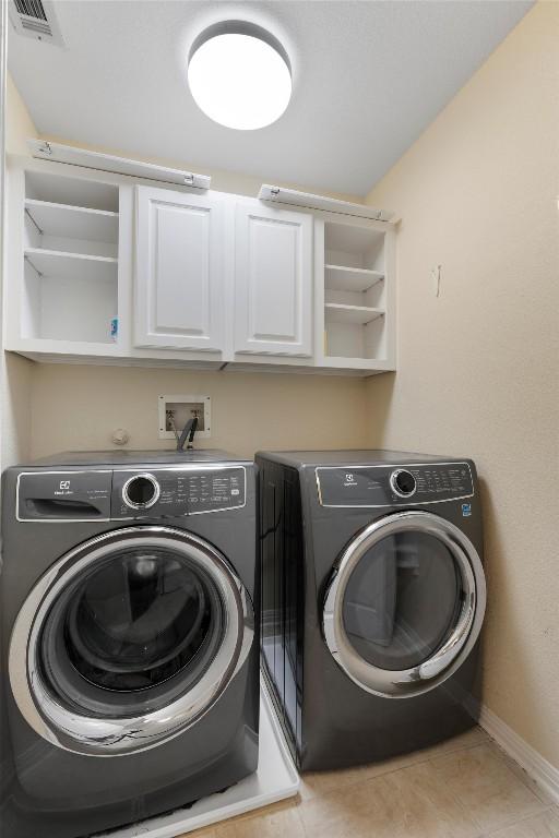 17112 Crescent Heights Trl, Austin, TX 78717 - laundry room with washing machine and clothes dryer, cabinet space, baseboards, and tile patterned floors