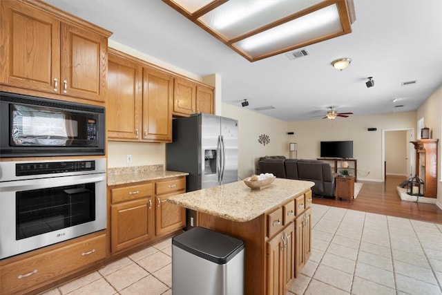 17112 Crescent Heights Trl, Austin, TX 78717 - kitchen with stainless steel appliances, light tile patterned floors, a ceiling fan, and a kitchen island